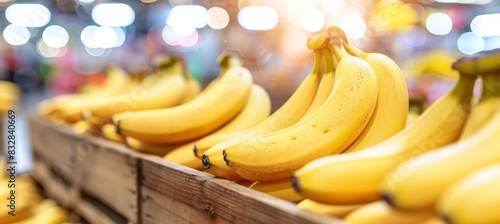 Ripe organic bananas in wooden crates at warehouse with blurred background and copy space