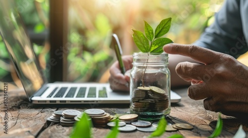 A person is inserting coins into a jar where a plant is sprouting, symbolizing financial growth and investment in nature.