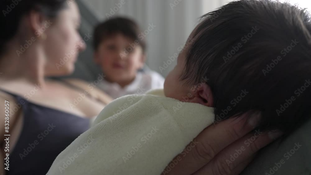 Mother and son admiring their newborn baby, with the baby nestled in mother's arms. blurred background focuses attention on the infant, intimate family bonding moment. Mother and son admiring their newborn baby, with the baby nestled in mother's arms. blurred background focuses attention on the infant, intimate family bonding moment.