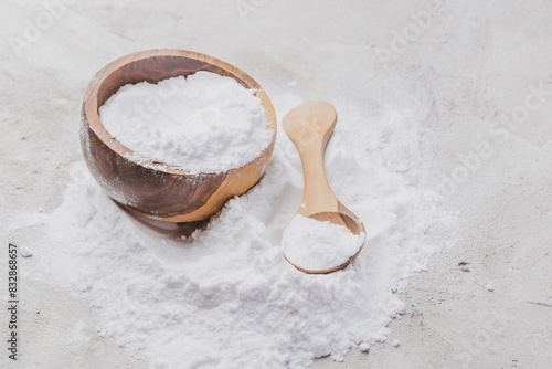 Baking soda in wooden container on rustic surface