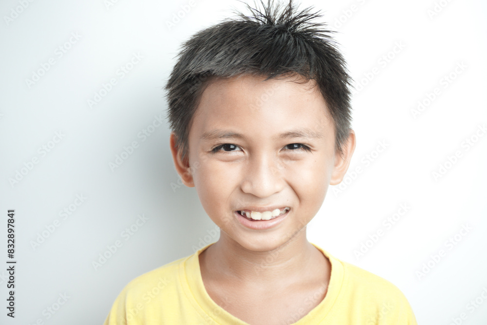 Portrait of a cute little Asian boy smiling against white background Portrait of a cute little Asian boy smiling against white background