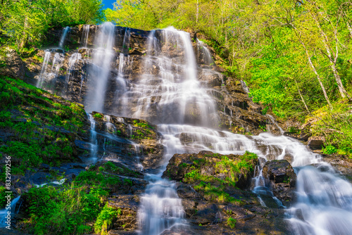 a waterfall that is falling down from a cliff in the woods © Wirestock