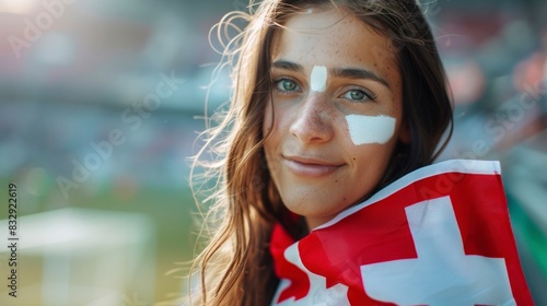 beautiful woman in a stadium with her face painted with the flag of switzerland photo