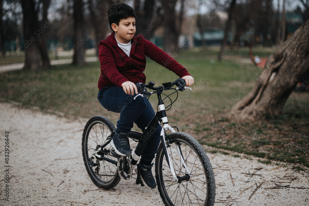 An active young kid enjoys a sunny day outdoors cycling in a green park. An active young kid enjoys a sunny day outdoors cycling in a green park.