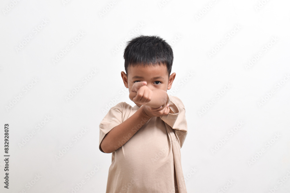 Image of Asian child posing pointing towards the front on a white background. portrait of an Asian boy Image of Asian child posing pointing towards the front on a white background. portrait of an Asian boy
