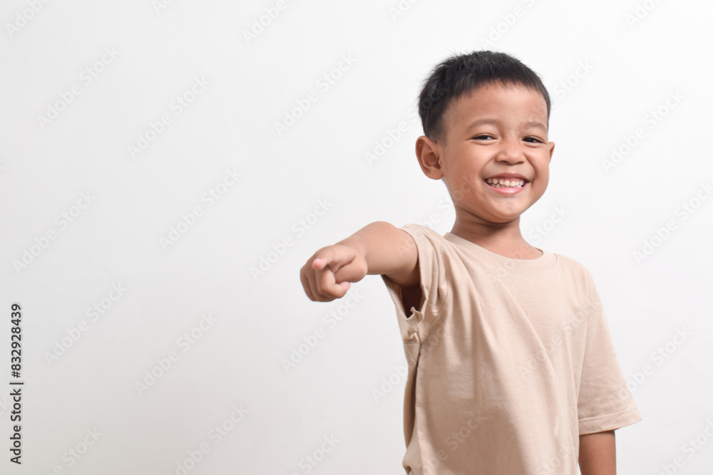 Image of Asian child posing pointing towards the front on a white background. portrait of an Asian boy Image of Asian child posing pointing towards the front on a white background. portrait of an Asian boy
