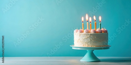 Birthday cake with four candles on a pastel blue background photo