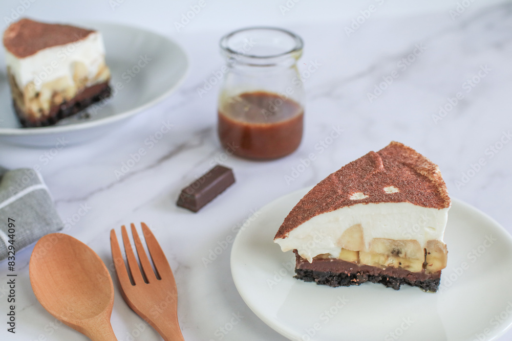 Homemade Banoffee cake made from bananas, whipped cream and a thick caramel sauce on table. Homemade Banoffee cake made from bananas, whipped cream and a thick caramel sauce on table.