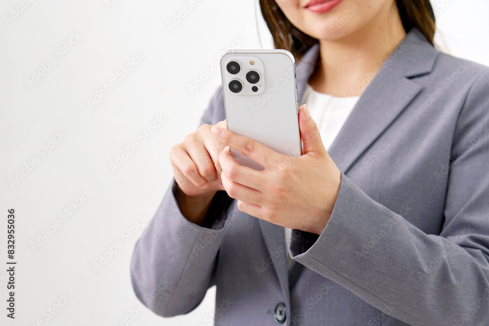 スマホを使う若いビジネスウーマン 白背景 顔無し スマホを使う若いビジネスウーマン 白背景 顔無し