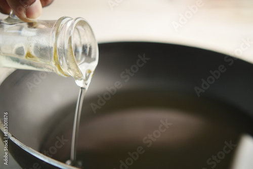  Pouring vegetable oil into frying pan.