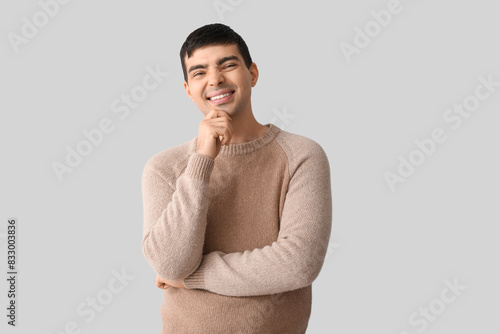 Happy young man on light ba...