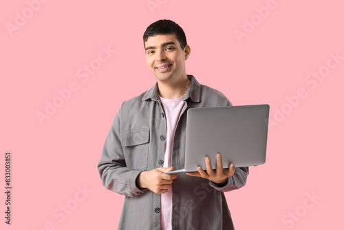 Happy young man with laptop...