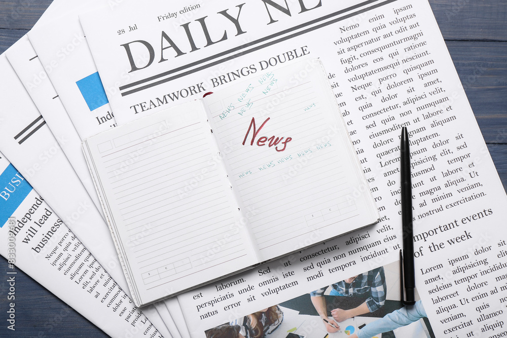 Newspapers with notebook and pen on blue wooden background Newspapers with notebook and pen on blue wooden background