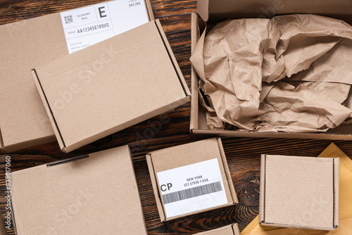 Cardboard packages with labels on wooden table, closeup photo