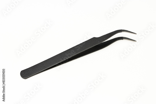 Black insulated tweezer isolated in white background. Used in electronic repair works. photo