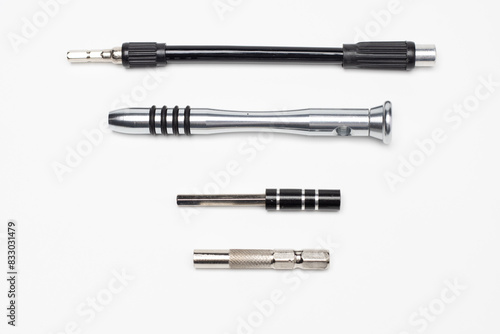 Parts of precision tool kit, contain aluminum screwdriver handle, extension bar, flexible bar and power tool bit holder. Isolated in white background.