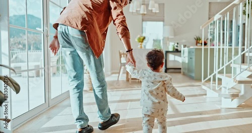 Dad, baby and learning to walk in a family home with balance, teaching and youth development. Support, care and love of a parent with step, lounge and house with kid and father together with helping photo