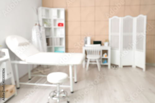 Blurred view of medical office with couch, folding screen and doctor's workplace © Pixel-Shot