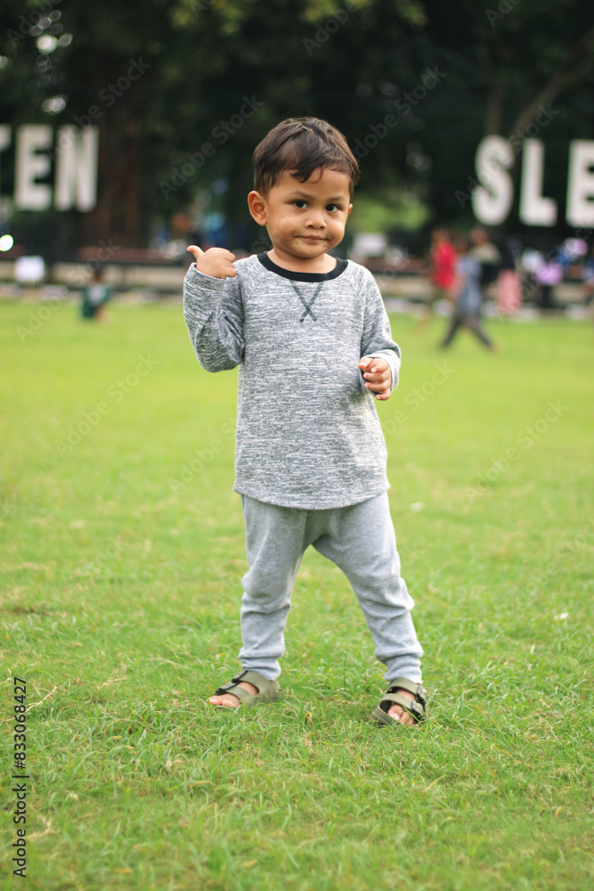A handsome young boy, nicely dressed showing an expression of joy with hands up in the air looking excited and happy to be playing outdoors.
A handsome young boy, nicely dressed showing an expression of joy with hands up in the air looking excited and happy to be playing outdoors.