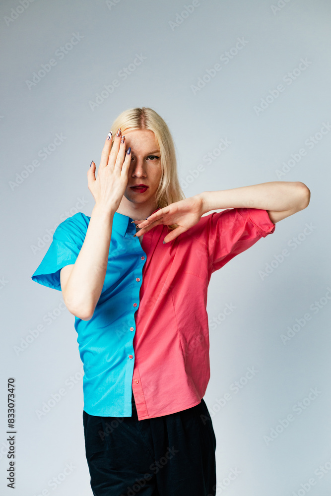 Studio photo of a man with make up on one half of face and rose and blue shirt Studio photo of a man with make up on one half of face and rose and blue shirt