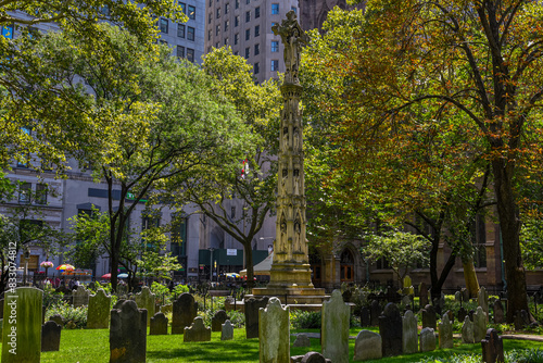 Fotografie The Astor Cross Monument among the Gravestones of the The Trinity Churchyard in
