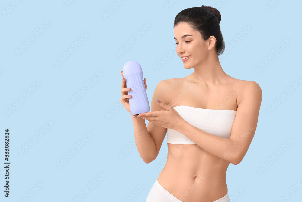 Beautiful young happy woman with liposoluble wax cartridge on blue background. Depilation concept Beautiful young happy woman with liposoluble wax cartridge on blue background. Depilation concept