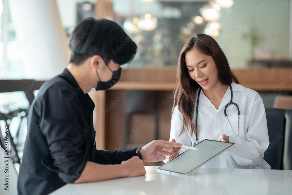 A young man consults with a female doctor in a modern clinic. The doctor is showing him information on a tablet device. Healthcare interaction scene. A young man consults with a female doctor in a modern clinic. The doctor is showing him information on a tablet device. Healthcare interaction scene.