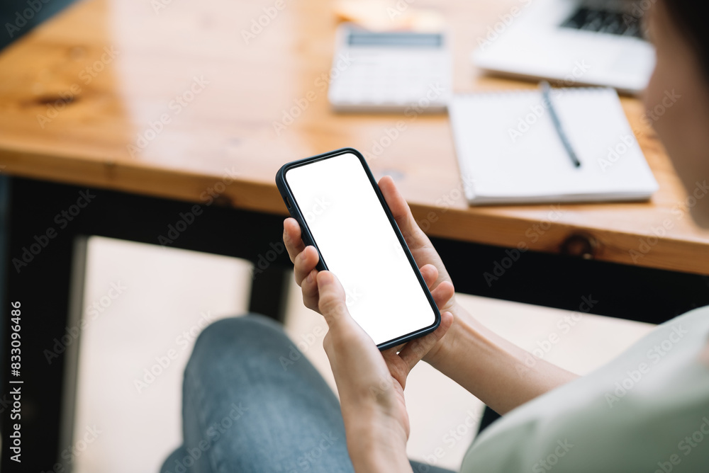 Person holding a modern smartphone with a blank screen, ready for design. Concept for mobile technology, communication, and online connectivity.