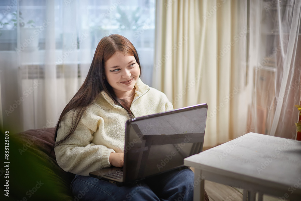 Fashionable young overweight plump female freelancer with portable computer, typing fast, working remotely from home. Brunette plus size girl using laptop Fashionable young overweight plump female freelancer with portable computer, typing fast, working remotely from home. Brunette plus size girl using laptop