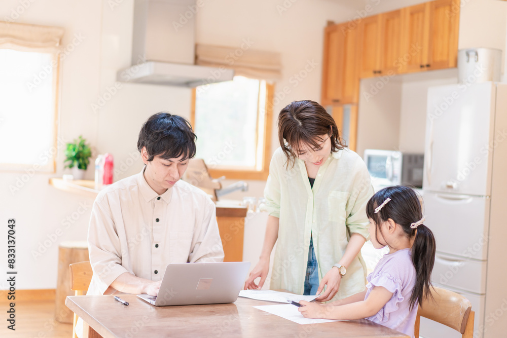 テレワークをする夫婦と子供