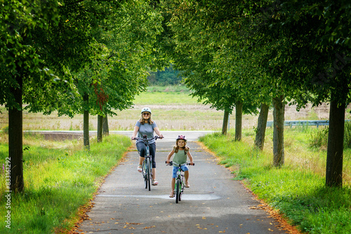 Wallpaper Mural Happy family is riding bikes outdoors and smiling. Mother and daughter, cute little preeschool girl on bicycles, active leisure and sports together. Torontodigital.ca