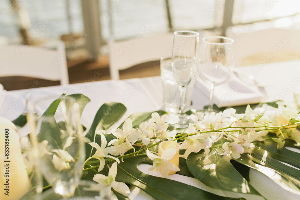 Tropical table setting for wedding with white linens and glassware Tropical table setting for wedding with white linens and glassware