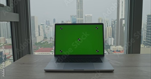 Backdrop of towering skyscrapers laptop sits desk green screen chromekey interface, symbolizing fusion of digital innovation within bustling metropolis green screen chromakey laptop urban life. photo