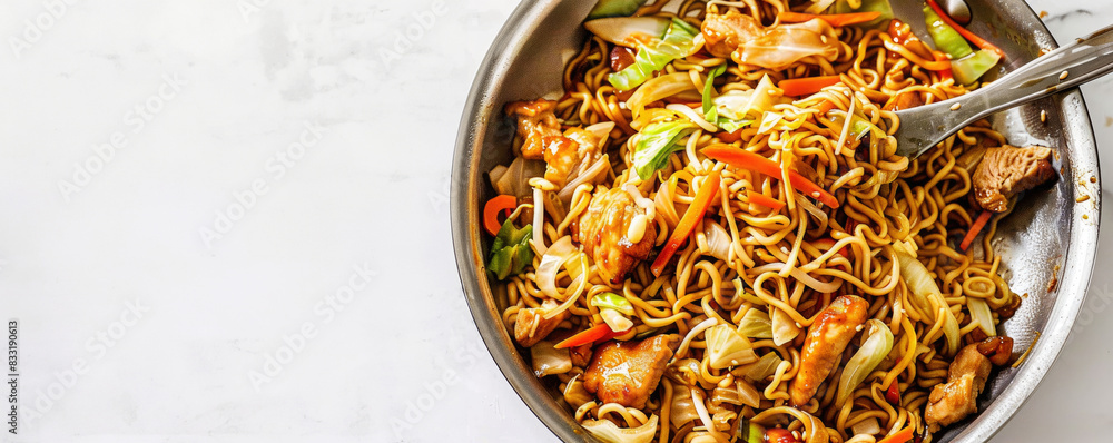 pan filled with asian cuisine chicken chow mein noodles, showcasing the colorful vegetables and tender pieces of meat within. With copy space.