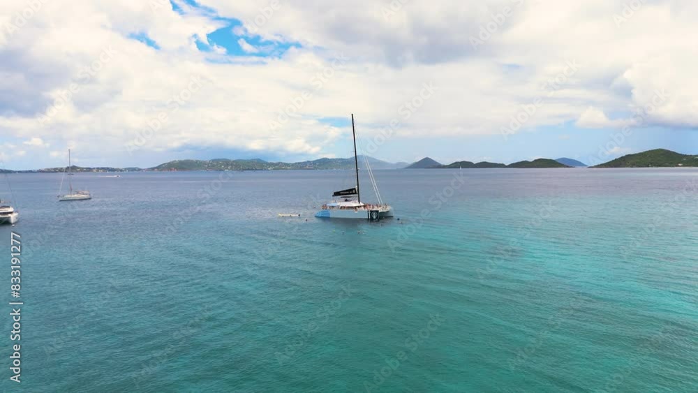 epic pull out shot of catamaran on teal blue waters in the tropics near a few private islands epic pull out shot of catamaran on teal blue waters in the tropics near a few private islands