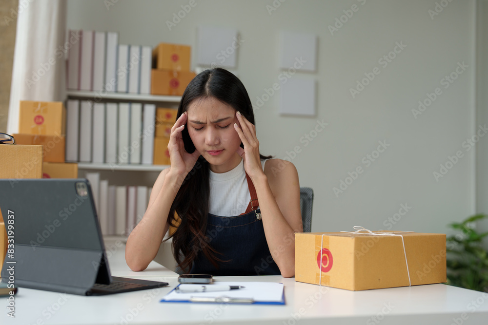Woman, independent business woman, selling products online, feeling stressed Tired from working for a long time Pack orders from customers who order through the website. online sales and e-commerce. Woman, independent business woman, selling products online, feeling stressed Tired from working for a long time Pack orders from customers who order through the website. online sales and e-commerce.