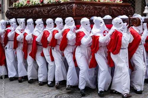 Penitents in White and Red March in Solemn Holy Week Observance