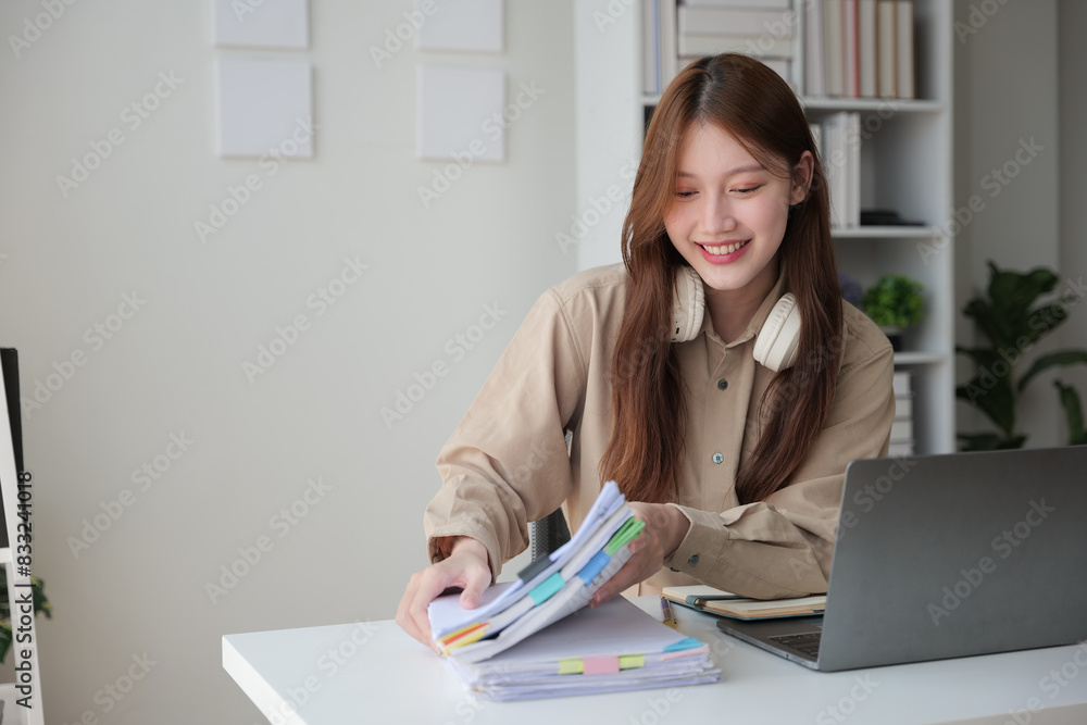 Young woman working indoor and using laptop, headset with happy and smile face. Young woman working indoor and using laptop, headset with happy and smile face.