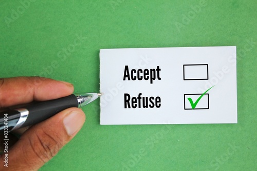 Fotografie hand holding pen and white paper with two word options Accept or refuse? Refuse