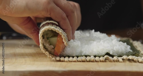 Raw Salmon Being Rolled into Maki Sushi Roll