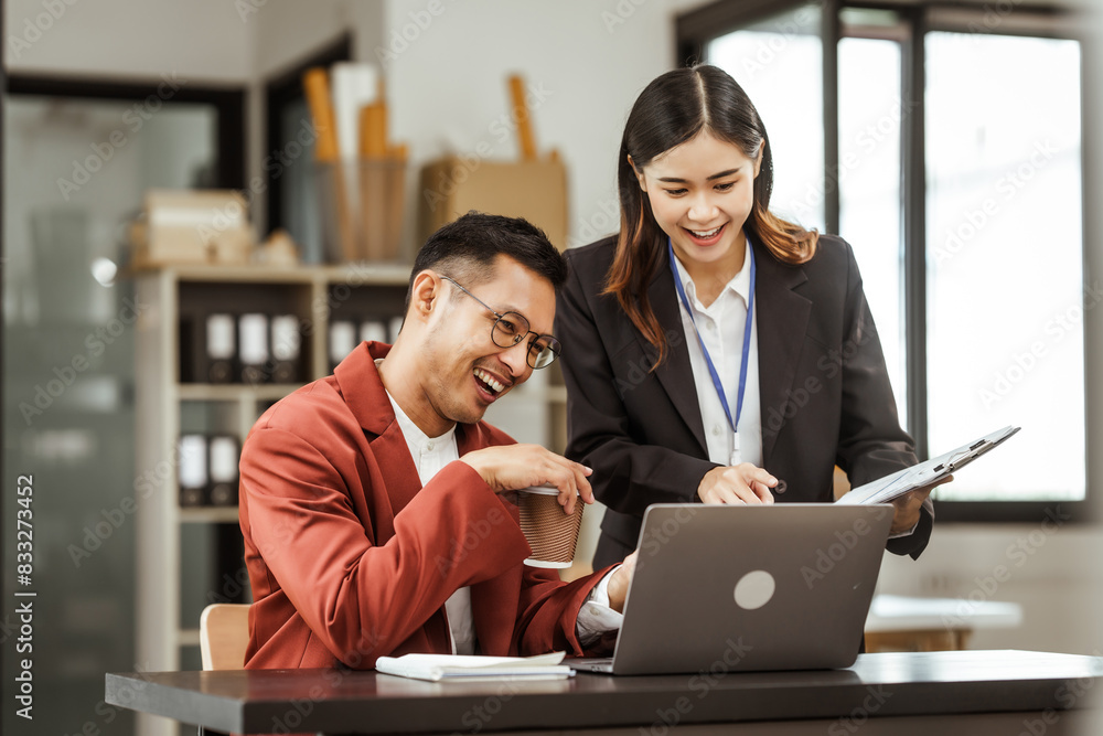 Middle-aged businessman and young Asian businesswoman work together at their desks, cooperation, collaboration, communication. teamwork, partnership, coordination to achieve mutual success. Middle-aged businessman and young Asian businesswoman work together at their desks, cooperation, collaboration, communication. teamwork, partnership, coordination to achieve mutual success.