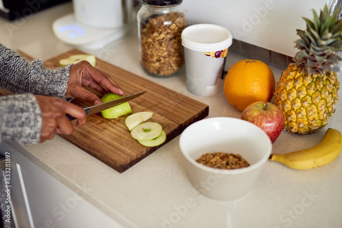 Home, apple and hands with breakfast on board for eating, healthy and diet nutrition in morning. House, counter or person with knife in kitchen for cutting, organic fruit or vegan recipe for snack
