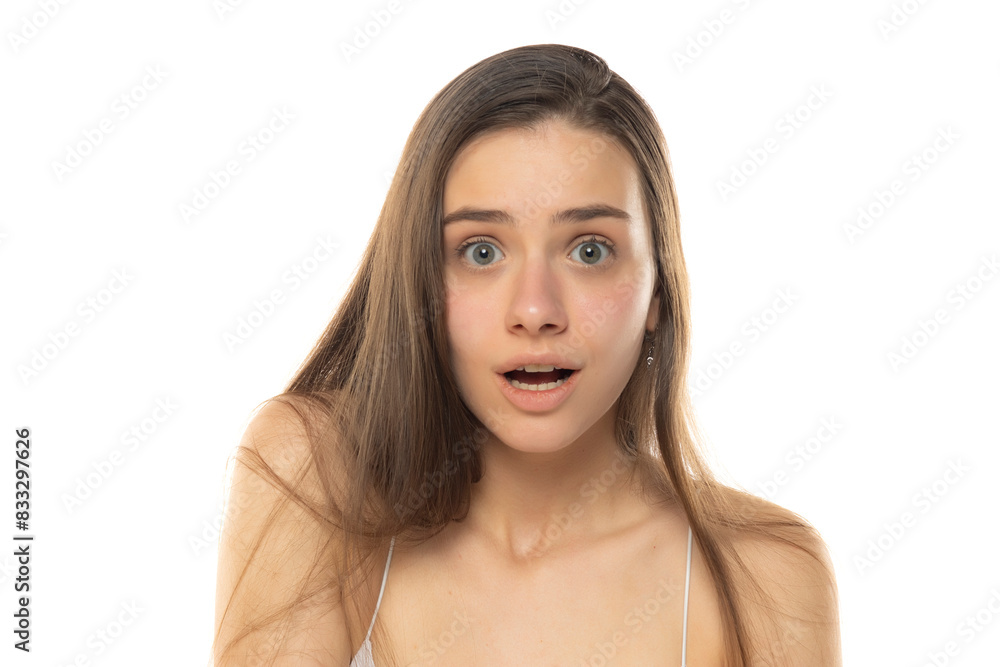 portrait of a young surprised teenage girl without makeup on a white background portrait of a young surprised teenage girl without makeup on a white background