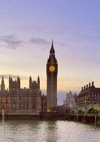 A view of Big Ben and the Palace of Westminster against a purple sunset sky across the River Thames at dusk in central London  England. 