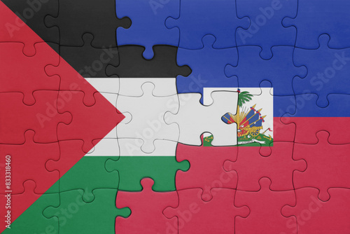 puzzle with the colourful national flag of haiti and flag of palestine.