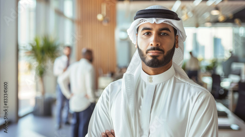 Confident Emirati businessman in traditional kandura at modern office photo