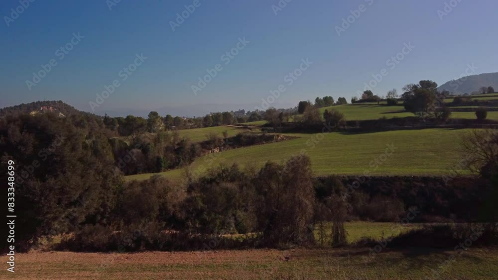 Rolling hills and lush greenery in the Marganell region, Barcelona, Spain under a clear blue sky Rolling hills and lush greenery in the Marganell region, Barcelona, Spain under a clear blue sky