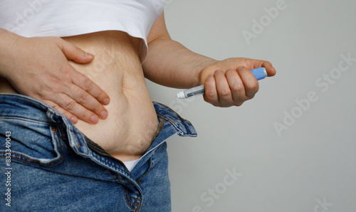 Woman making Injection Pen in her Stomach. Semaglutide or Insulin Injection Diabetes Drug Being Used For Weight Loss.