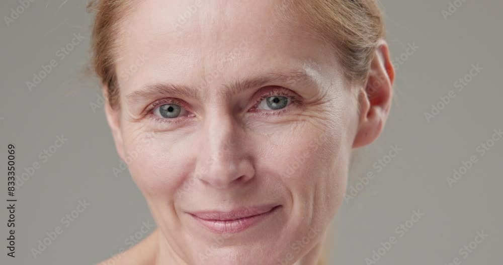 Real people - concept of age, beauty, health and dry skin care - beautiful mature Caucasian middle-aged woman in her 50s looks with a calm confident look at the camera, smiles a bright toothy smile Real people - concept of age, beauty, health and dry skin care - beautiful mature Caucasian middle-aged woman in her 50s looks with a calm confident look at the camera, smiles a bright toothy smile