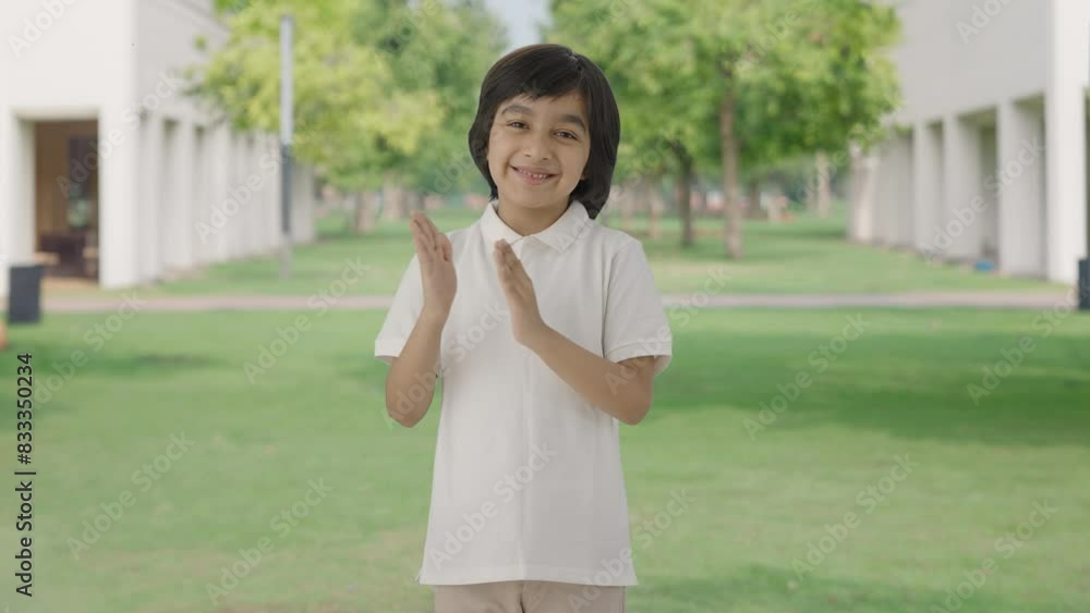 Happy Indian boy clapping and appreciating in park Happy Indian boy clapping and appreciating in park